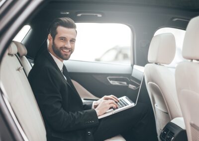 Businessman in suit sitting in car's back seat