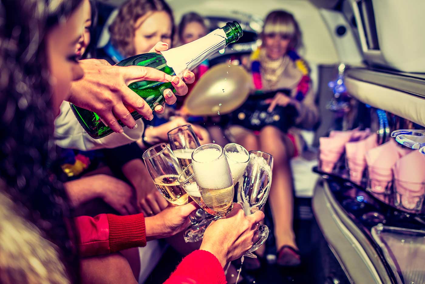 Group of friends toasting champagne in a limousine Group of friends toasting champagne in a limousine