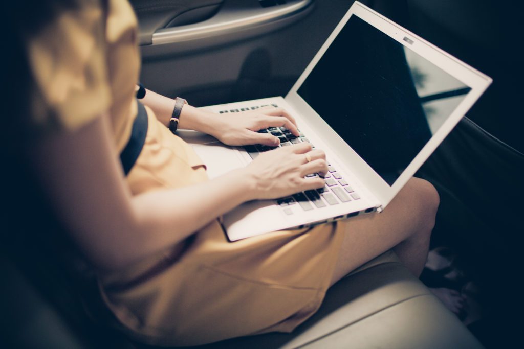 Businesswoman,With,Document,And,Laptop,In,Car
